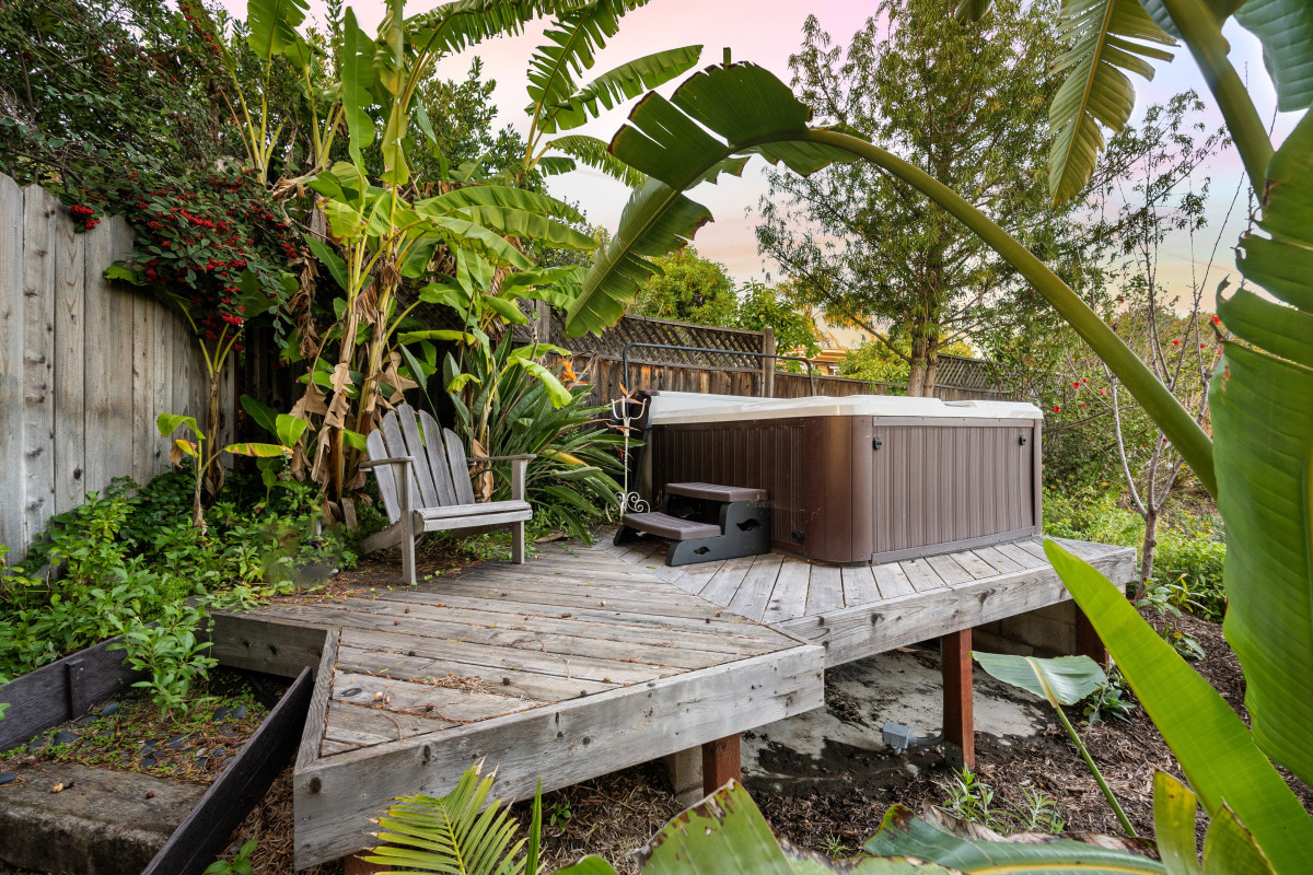 terrasse-en-bois-avec-bain-a-remous-exterieur-entoure-dune-vegetation-luxuriante